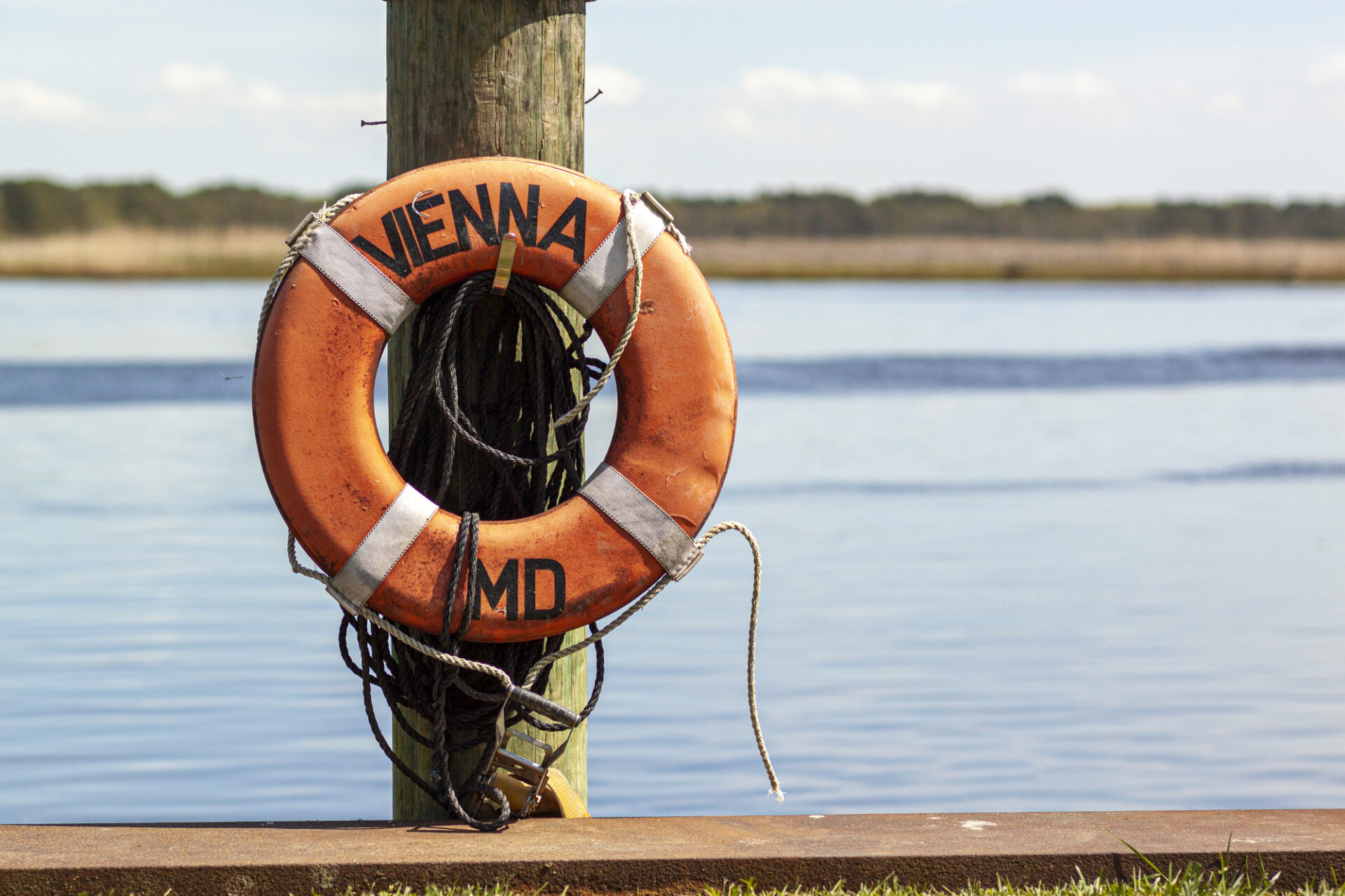 A lifebuoy attached to a dock post on the pier in Vienna, Maryland. This is a historic colonial era town on the coast of Nanticoke river, eastern shore of Chesapeake bay. Isolated close up image.